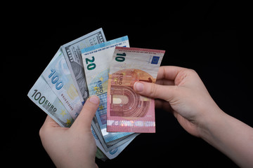 Hand holding American dollar  isolated on black background