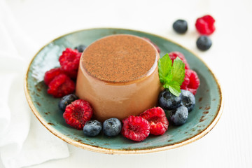 Delicious home-made chocolate dessert Panna cotta. Cream-caramel, caramel custard, with raspberries and blueberries.