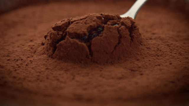 closeup macro of chocolate texture cacao powder with a cream texture under and spoon take a part of it