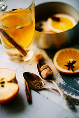 A glass of hot mulled wine, spices, cinnamon, star anise, brown sugar and nuts on a wooden board