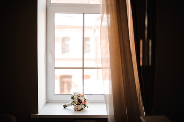 Beautiful wedding bouquet of flowers on the window sill