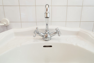 detail of classic faucet and white sink