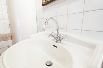 detail of classic faucet and white sink