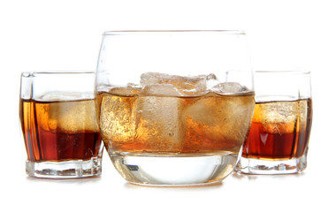 Glass jars with whiskey and ice on white background