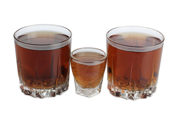 Glass jars with whiskey and ice on white background