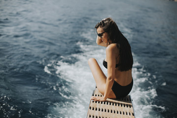 Fototapeta premium Pretty woman relaxing on the yacht on sea at sunny day