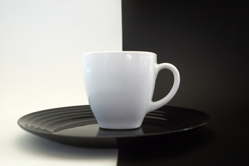 Cake on a black plate and coffee in a white Cup.