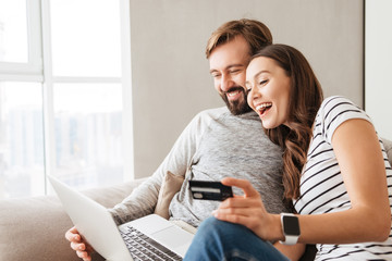Portrait of a laughing young couple shopping online