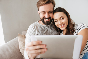 Portrait of a happy young couple using tablet computer