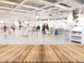 Obraz premium Wooden board empty table blurred shopping mall background. Perspective brown wooden table blur in department store background - can be used for display or montage your products. Mock up for of product