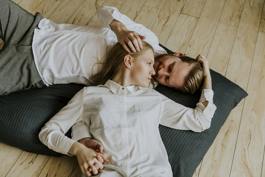 Loving couple lying and kissing on the floor
