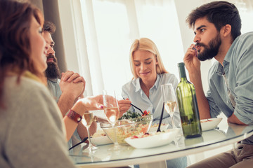 Group of happy young friends eating and having fun at home