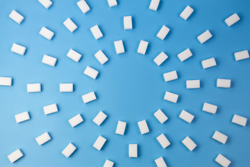 White sugar cubes on blue background
