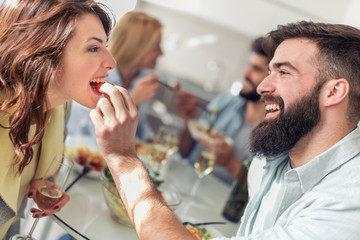 Group of happy young friends eating and having fun at home