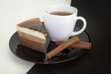 Cake on a black plate and coffee in a white Cup.