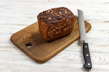 one loaf of bread on a cutting board with knife
