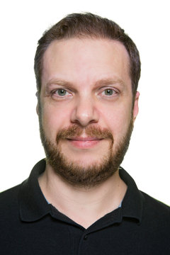 Portrait of adult bearded man against white background.