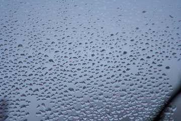 Drops of water on the glass. Blue window background.