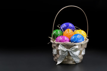 colorful easter eggs in basket isolated on black background