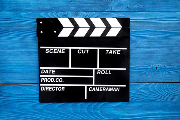 Film concept. Clapperboard on blue wooden background top view copyspace
