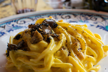 Pasta  spaghetti with black truffle and olive oil on a white plate.