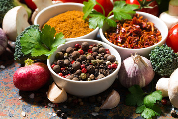 assortment of spices and fresh organic vegetables on a dark background, closeup