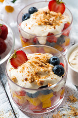 fresh fruit dessert with custard in glasses, vertical top view closeup