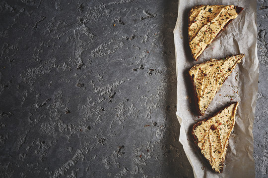 three slices of whole wheat bread with hummus on the grey concrete backdrop