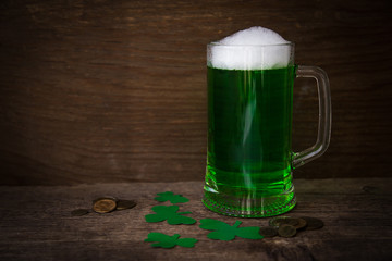 St Patrick's Day concept green beer with shamrock and coins on w