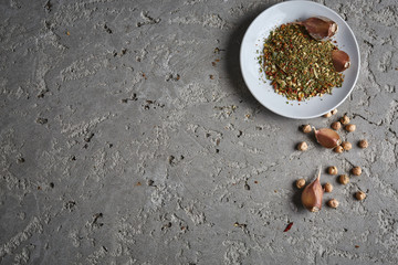 a plate of spices, chickpea and garlic on the grey concrete backdrop