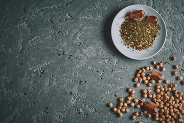 a plate of spices, chickpea and garlic on the grey concrete backdrop