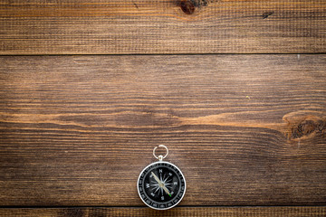 Compass on dark wooden background top view copy space