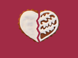 Broken gingerbread heart isolated on red background