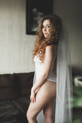 Naklejka premium Luxury bride in white dress posing while preparing for the wedding ceremony