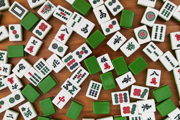 White-green tiles for mahjong on a brown wooden background. No empty place.