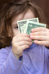 Young kid girl holding money in hands