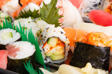 roll with avocado, crab and caviar of flying fish on a background of sushi and rolls close up