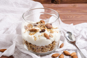 muesli with natural yoghurt, nuts and dried fruits in a glass jar