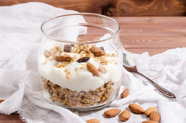 muesli with natural yoghurt, nuts and dried fruits in a glass jar