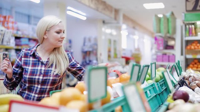 girl buys fruit and vegetables in shop