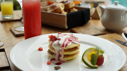 American pancakes with creams and strawberry jam