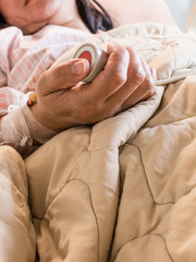 Woman pushing emergency button in hospital bed