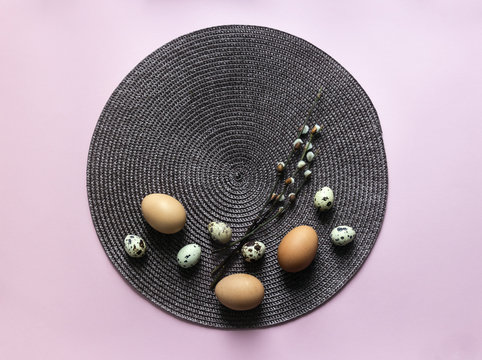 on a pink background eggs eggs chicken quail branches willows bloomed round napkin brown easter top view 