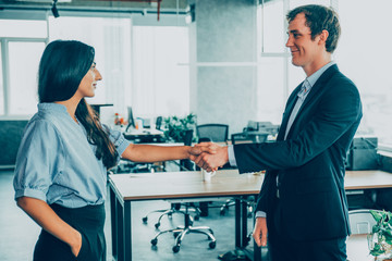 Pleased male manager greeting with new colleague