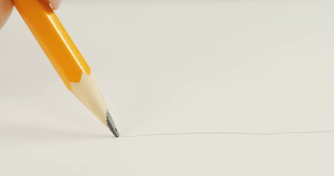 Macro shooting of the pencil drawing the line on the white paper and it breaking. Close up