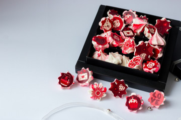 Obraz na płótnie Canvas meringue pink with red flowers in black box