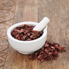 Blue flag root herb used in alternative herbal medicine to ease constipation and to detox and has many other health benefits. In a mortar with pestle on rustic wood background. Iris versicolour.