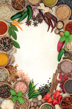 Herb and spice abstract background border with fresh and dried herbs and spices on parchment paper and rustic wood. Top view.