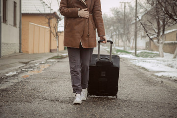 Young woman with suitcase on the street