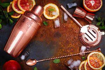 Bar accessories, drink tools and cocktail ingredients on rusty stone table. Flat lay style